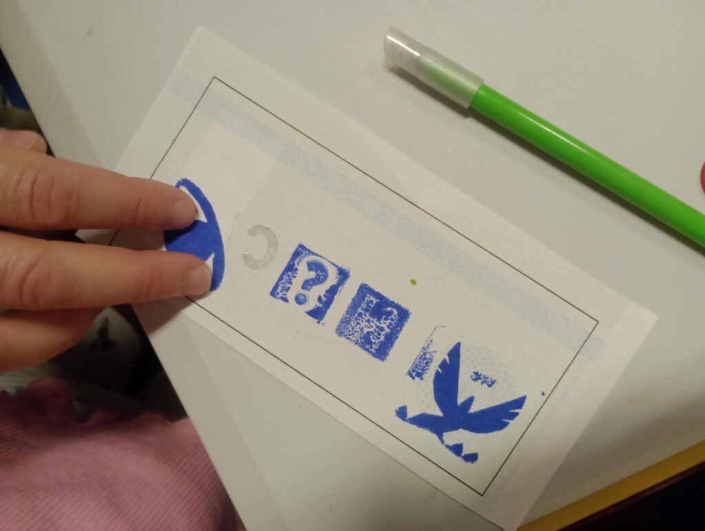Manos colocan pegatinas sobre una ficha de la actividad